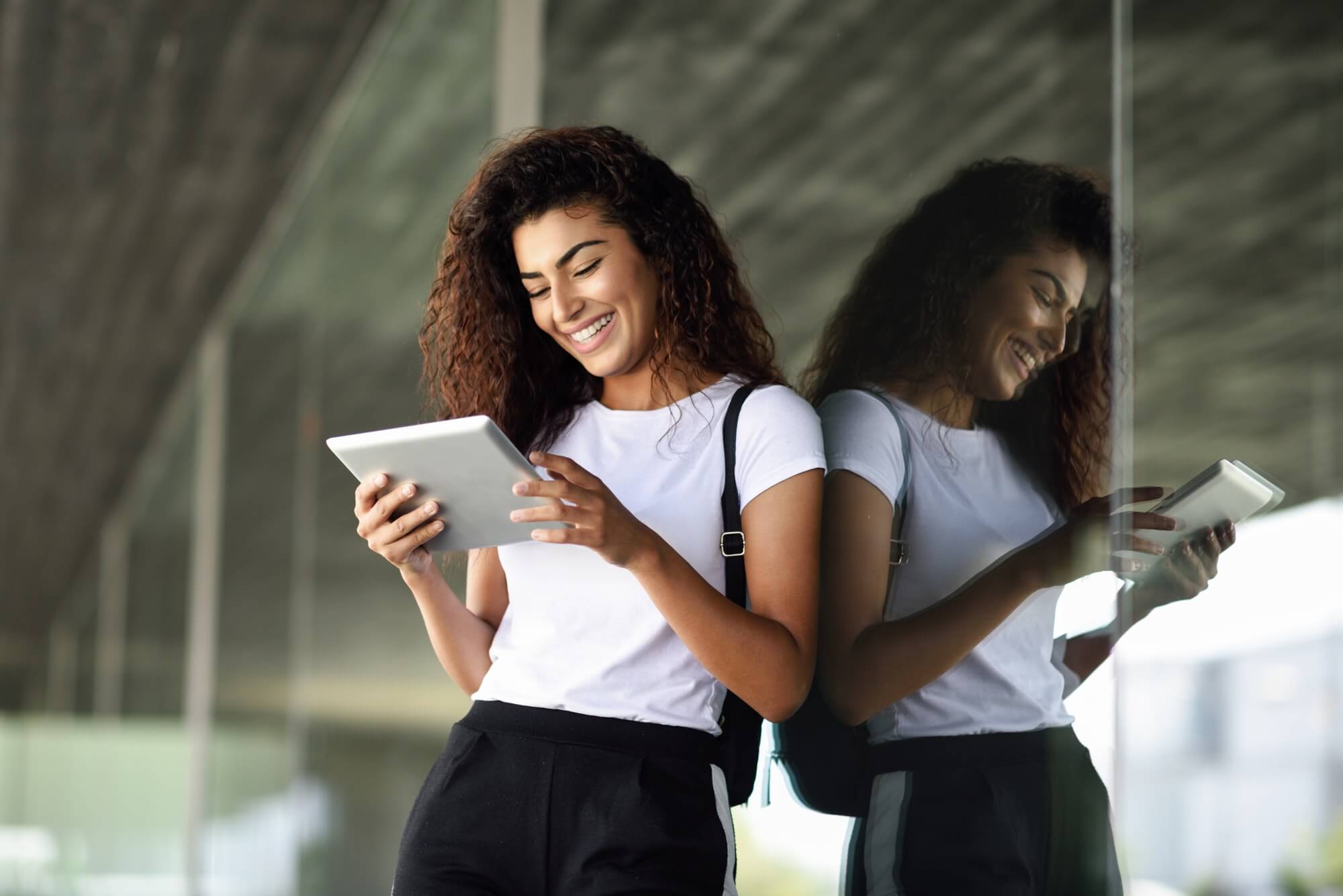 happy-young-arab-woman-using-digital-tablet-in-business-background.jpg